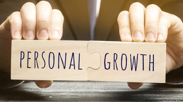 Hands joining two puzzle blocks reading personal growth
